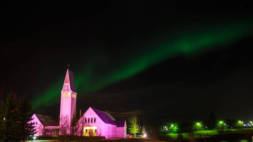 Church in Selfoss illuminated at night under northern lights, South Iceland townscape with aurora over the skyline Church in Selfoss illuminated at night under northern lights, South Iceland townscape with aurora over the skyline