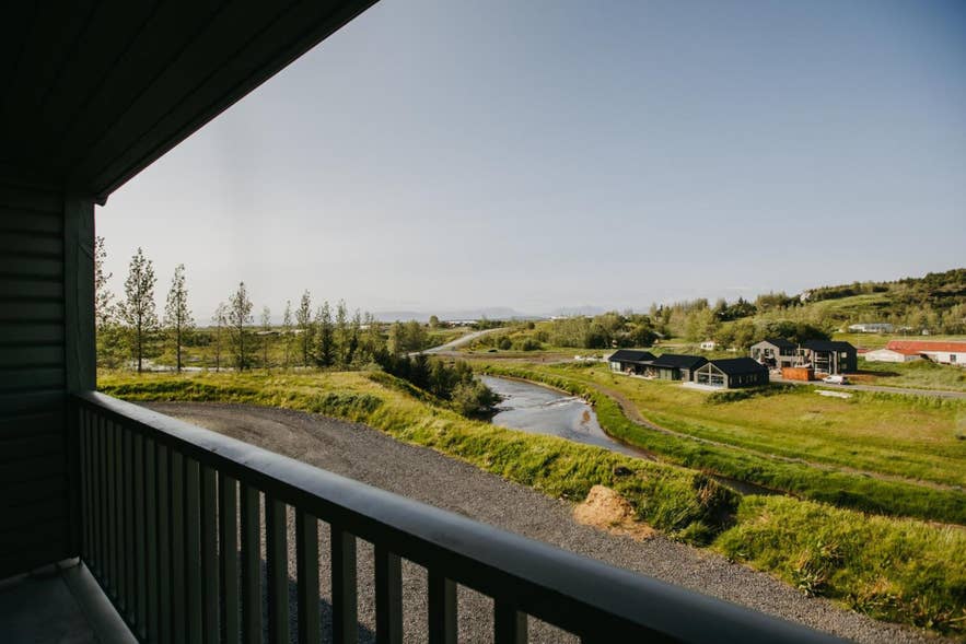 Blick von einem Balkon auf das Dorf Fludir, den Fluss Litla-Laxa und die Landschaft in Südisland nahe dem Goldenen Kreis.
