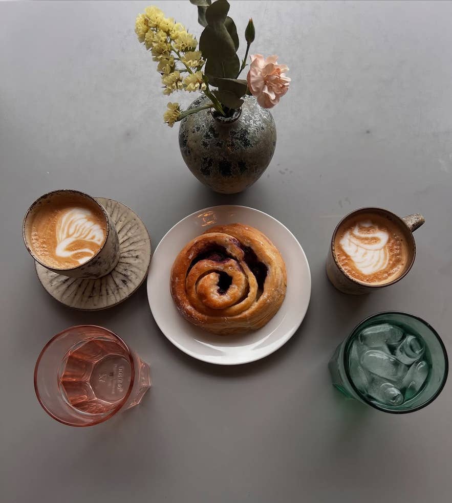 Top view of cups of coffee with pastries on a table.