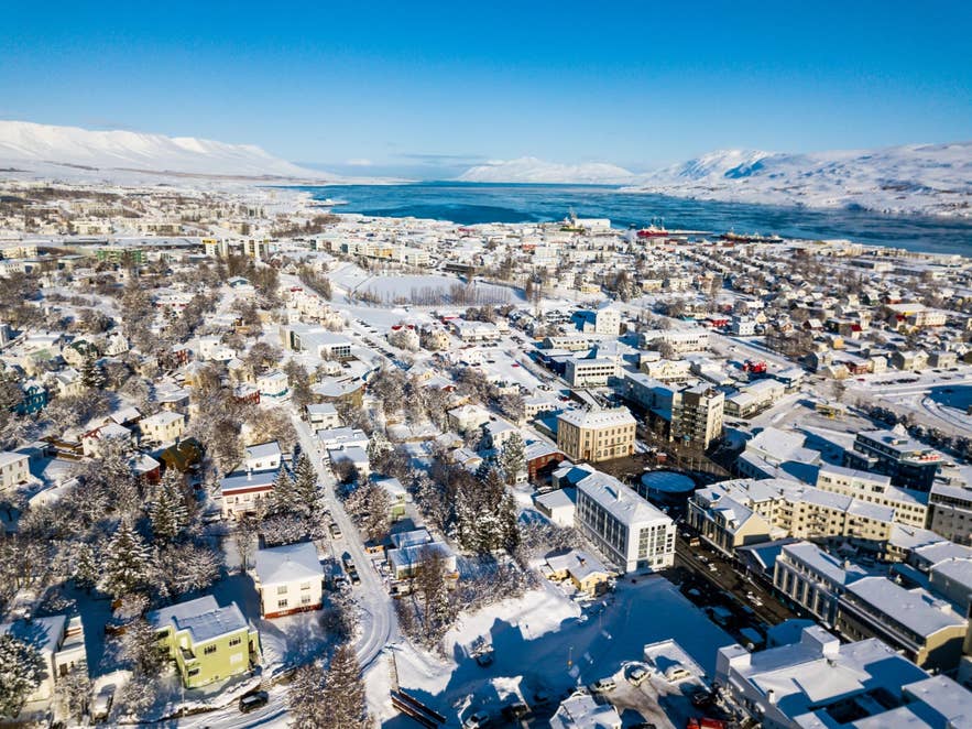 雪に覆われたアークレイリの空撮。フィヨルドと山々が広がる、アイスランド地図の定番風景。