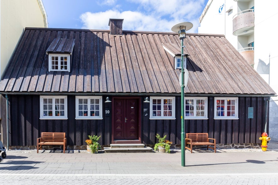 Adalstraeti 10, the oldest house in Reykjav&iacute;k, featuring black timber siding and a classic gabled roof, representing early 18th-century urban Icelandic design.