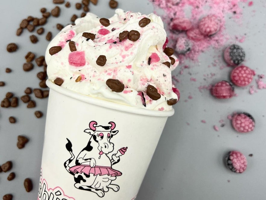 Creamy mix-in ice cream from &Iacute;sb&uacute;&eth; Huppu topped with chocolate pieces and berries in a branded cup on a gray background