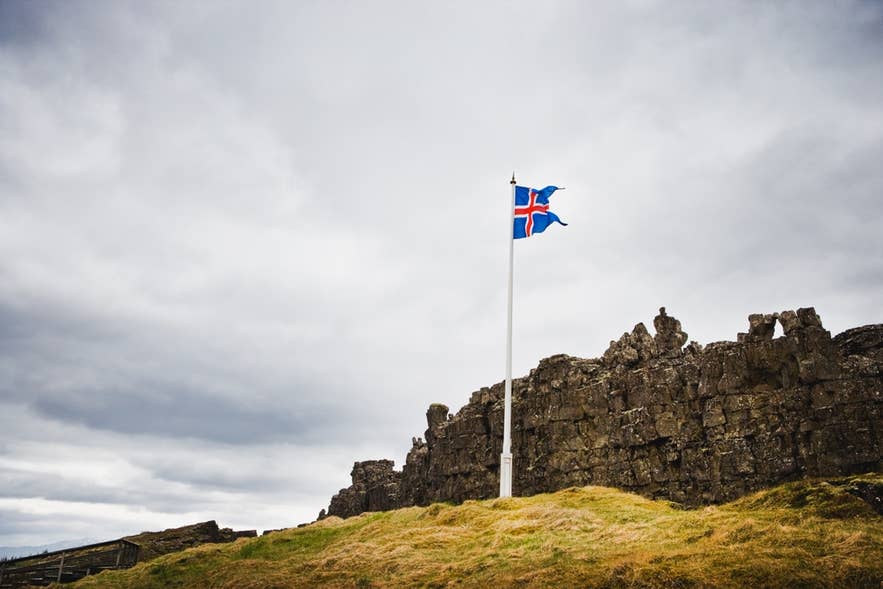 The Icelandic flag flies above Logberg Law Rock in Thingvellir National Park.
