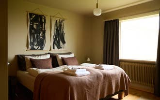 A cozy bedroom with a double bed and warm lighting at Eyri Farm.
