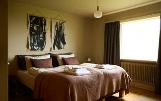 A cozy bedroom with a double bed and warm lighting at Eyri Farm.