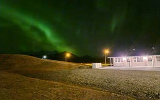 Aurora lights glowing above mountains and countryside in Iceland.