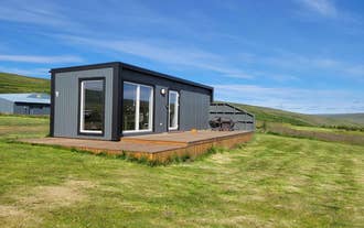 One of the cottages in Hotel Studlagil Canyon with a wooden patio.