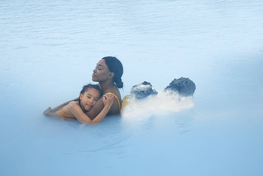 Islanda con bambini che si rilassano alla Laguna Blu vicino a Grindavik, godendosi insieme la spa geotermica.