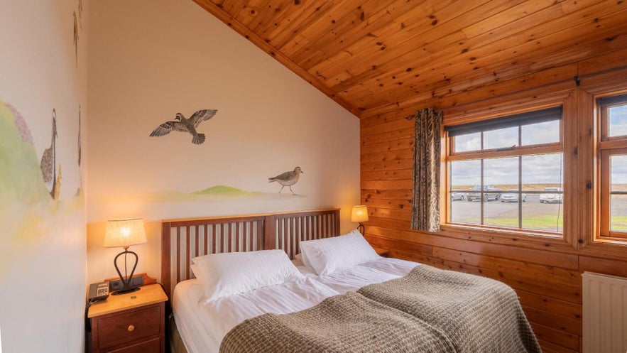 Iceland with kids staying in a cozy wooden cabin near Vik on the South Coast with views of open countryside.