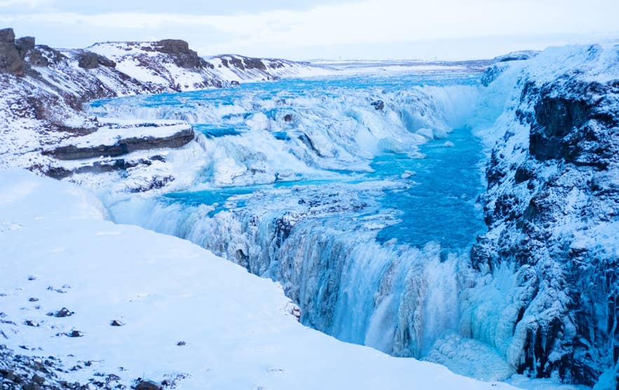 Cascata Gullfoss in inverno con canyon ghiacciato e fiume turchese, presente sulle mappe dell’Islanda.