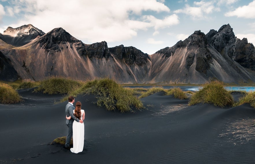Icelandic wedding couple at Stokksnes black sand dunes with Vestrahorn mountain in East Iceland. Icelandic wedding couple at Stokksnes black sand dunes with Vestrahorn mountain in East Iceland.