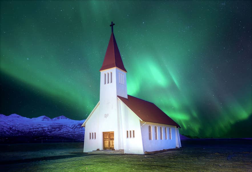 Isländische Kirche unter den Nordlichtern bei Vík im Süden Islands.