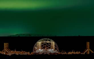 The northern lights beam over an igloo at Aurora Igloo North in Iceland.