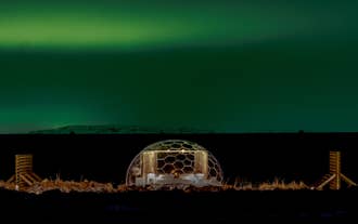 The northern lights beam over an igloo at Aurora Igloo North in Iceland.