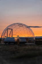 En smuk solnedgang bag en iglo ved Aurora Igloo North.