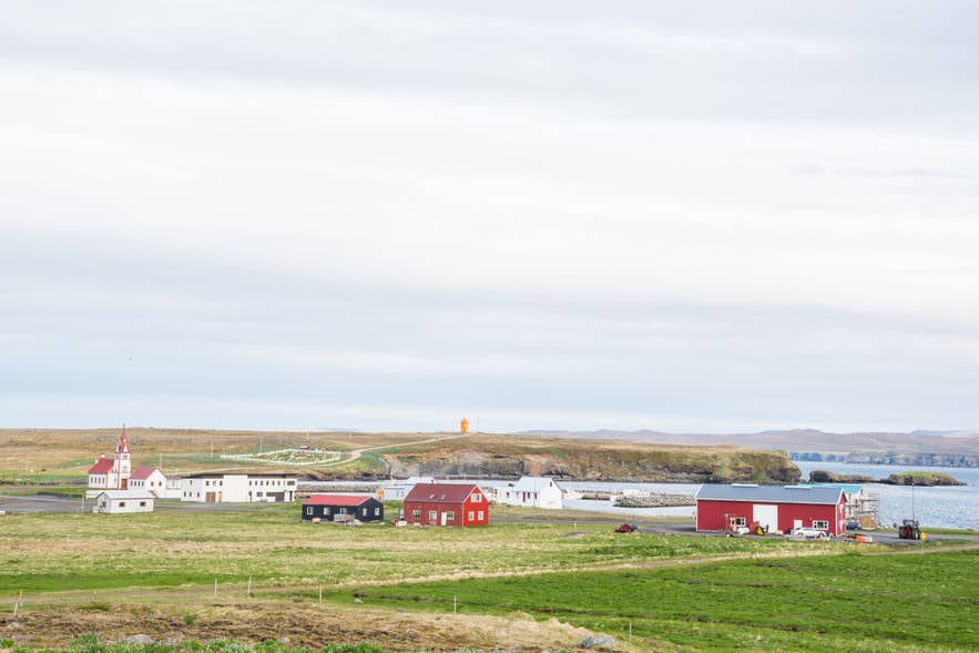Colorful houses and a red-roofed church in Raufarhofn village overlooking the harbor and Arctic coastline in North Iceland.