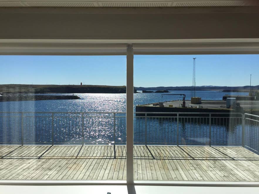 View from Hotel Nordurljos balcony overlooking Raufarhofn harbor and the Arctic coastline on a sunny day in North Iceland.