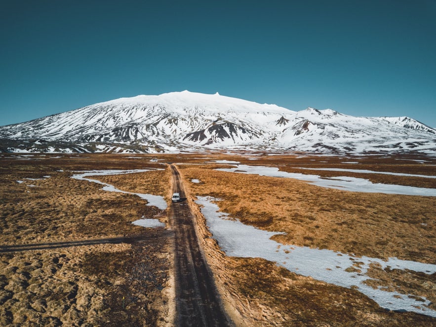Vehicle driving toward Snaefellsjokull Glacier across open plains on the Snaefellsnes Peninsula in West Iceland. Vehicle driving toward Snaefellsjokull Glacier across open plains on the Snaefellsnes Peninsula in West Iceland.