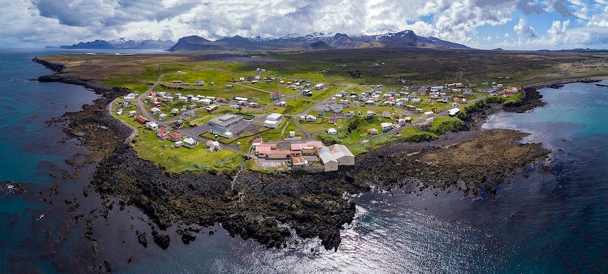 Aerial view of the coastal village of Hellissandur on the Snæfellsnes Peninsula in West Iceland, surrounded by lava fields and the North Atlantic Ocean.