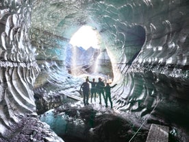 A group of travelers stand inside the spectacular Katla ice cave during a guided tour.