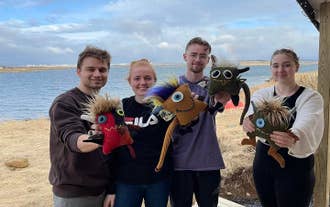 En gruppe venner poserer med deres Skrimsli-legetøj i Island.
