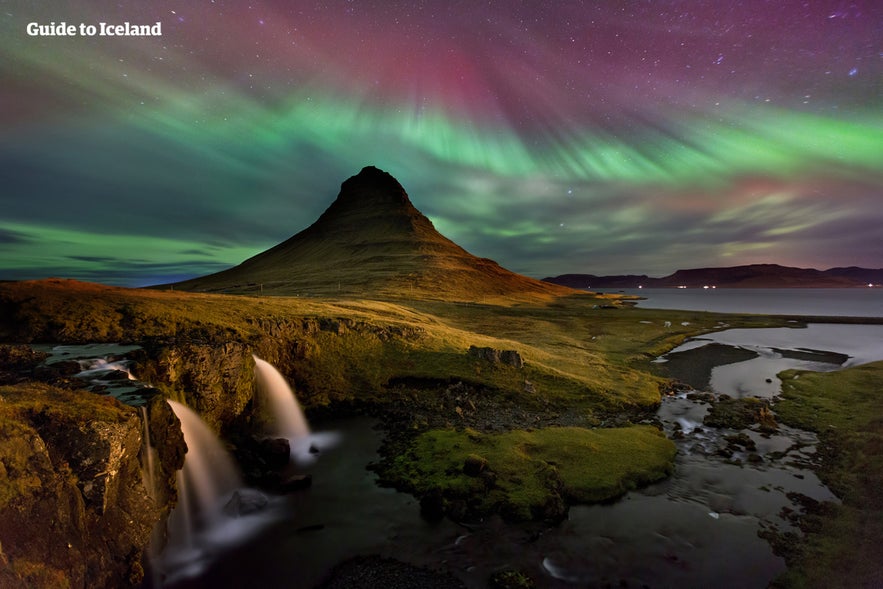 Kirkjufell below the dancing northern lights.