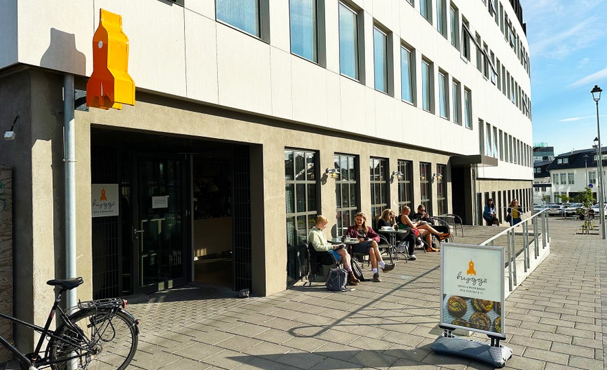 People sitting outside Hygge Coffee & Micro Bakery on a sunny day in Reykjavik.