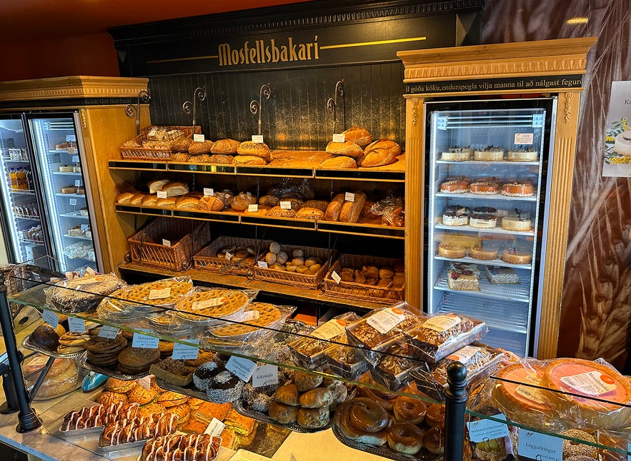 Pastry and bread display at Mosfellsbakari bakery in Mosfellsbær, Iceland, featuring cakes, rolls and Icelandic treats