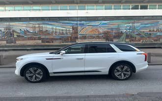 An SUV for a private Blue Lagoon transfer is parked in front of a building in Iceland.