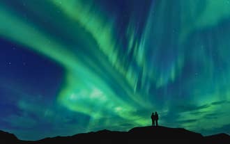 Northern lights stretching across the night sky above Iceland’s rugged landscape.