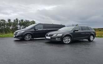 Luxury van and station wagon parked on roadside in Iceland offering private airport transfer services.