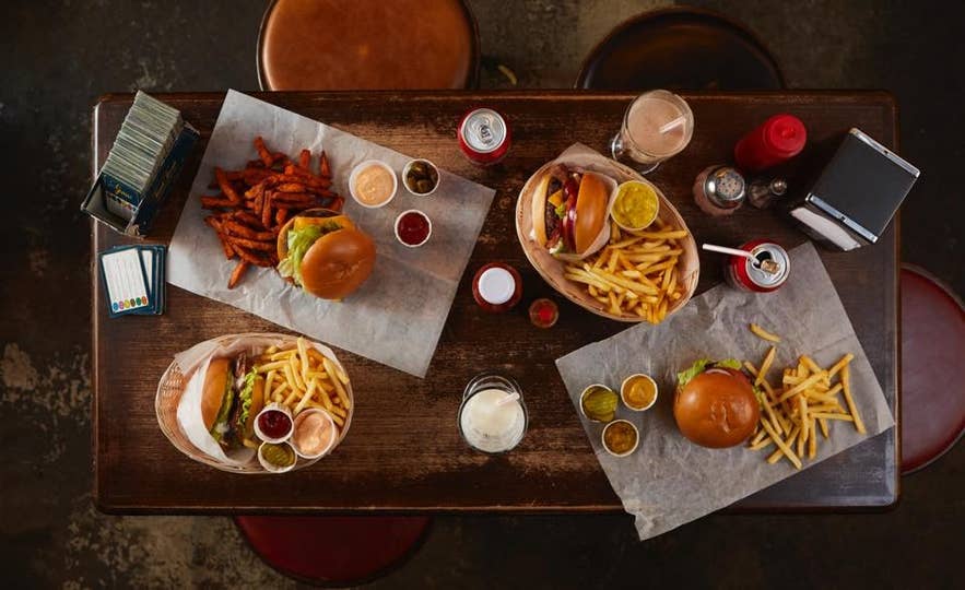 Overhead view of burgers, fries, and dipping sauces served on a table at Hamborgarabulla Tomasar in Reykjavik. Overhead view of burgers, fries, and dipping sauces served on a table at Hamborgarabulla Tomasar in Reykjavik.