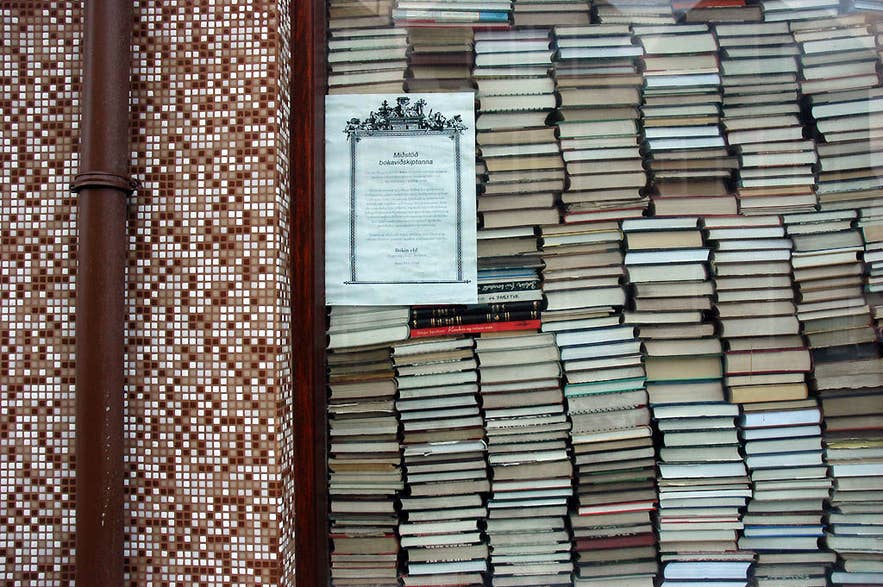กองหนังสือที่จัดวางในหน้าต่างร้านหนังสือในไอซ์แลนด์ นำเสนอวรรณกรรมท้องถิ่นและของที่ระลึกสุดพิเศษ