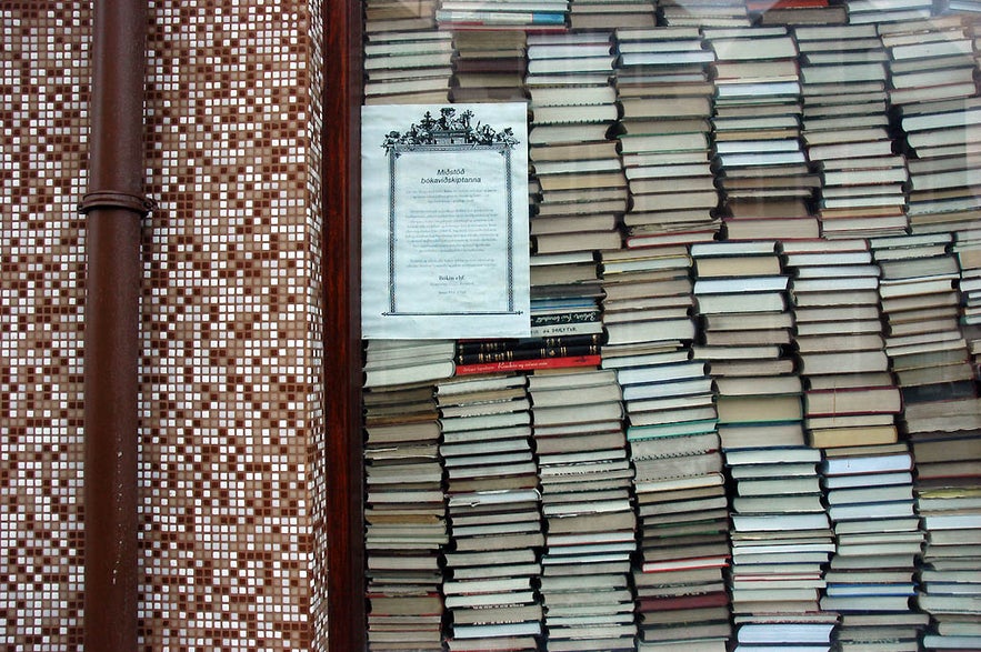 Stacked books in an Iceland bookstore window, showcasing local literature and unique souvenirs