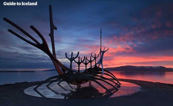 Himmelen lyser opp i strålende farger når solen går ned bak skulpturen Sun Voyager i Reykjavik.