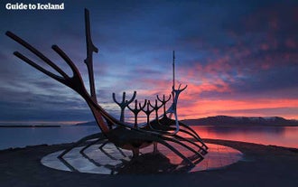 Niebo rozświetla się wspaniałymi kolorami, gdy słońce zachodzi za rzeźbą Sun Voyager w Reykjaviku.