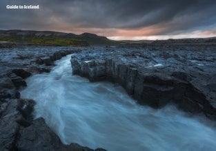 Un potente fiume in mezzo a un paesaggio aspro nell'Islanda occidentale.