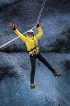Une personne pose pour une photo sur une tyrolienne traversant un glacier dans le sud-est de l'Islande.