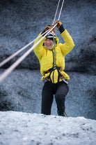 Une personne souriante profite d'une expérience de tyrolienne sur un glacier près de Skaftafell.