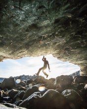 A person hangs from an ice formation on the Vatnajokull glacier.