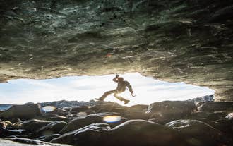 A person hangs from an ice formation on the Vatnajokull glacier.