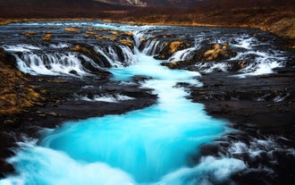 A waterfall with pale-blue waters in Iceland.