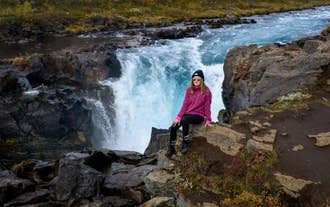 Photo d'un voyageur posant devant la cascade de Bruarfoss en Islande.