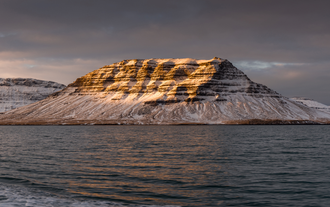 Sun shines on a stunning snow-covered peak on the Snaefellsnes Peninsula.