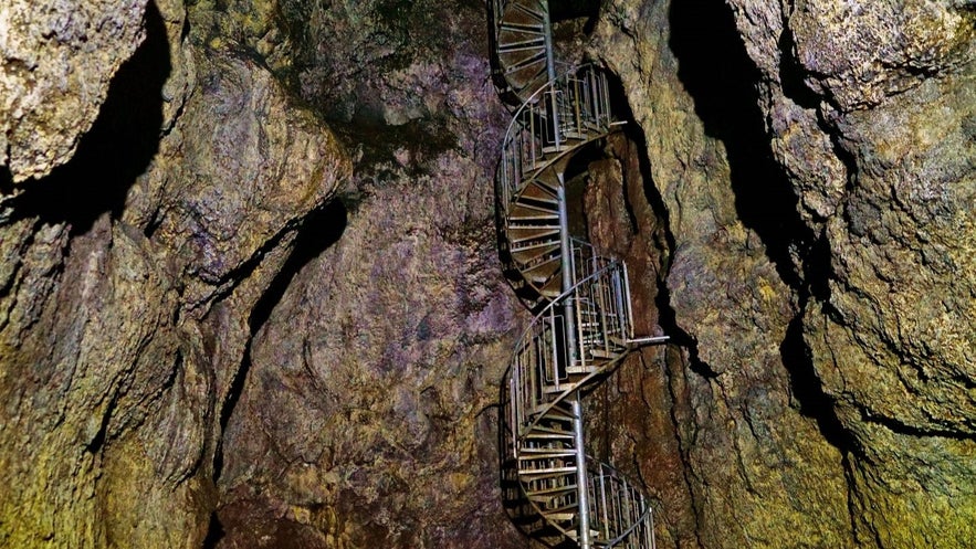 Spiral staircase inside Vatnshellir Cave in Snæfellsnes, Iceland, showing the descent into the lava tube's ancient volcanic rock formations.