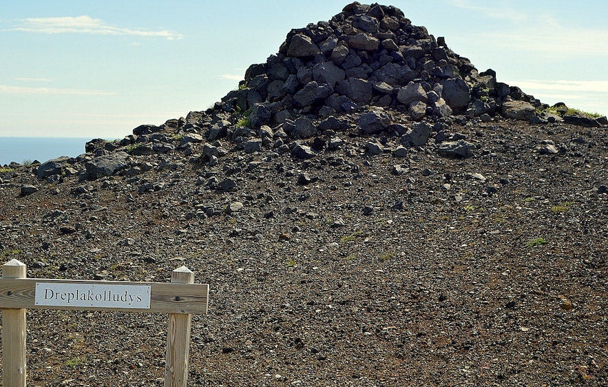 Draped in legend, the Dreplakolludys cairn on the Snæfellsnes Peninsula in West Iceland marks the burial site of Icelands first serial killer in a rocky volcanic landscape.