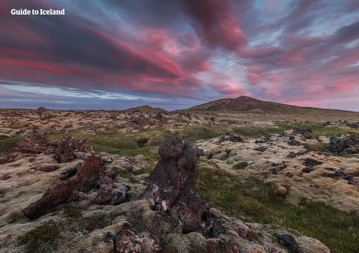 A rugged lava field on the Reykjanes Peninsula with the colors of the setting sun adorning the sky overhead.