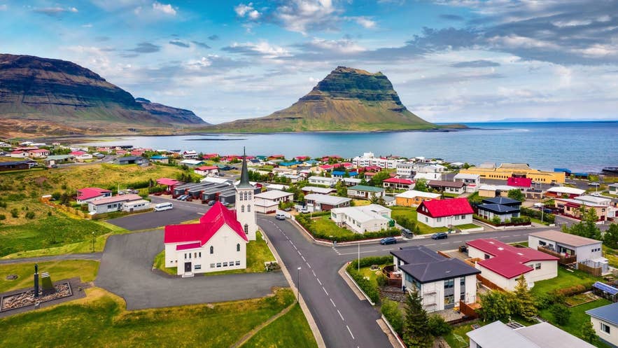 Colorful town of Grundarfjörður on Iceland’s Snæfellsnes Peninsula, with Kirkjufell mountain rising in the background beside the sea.