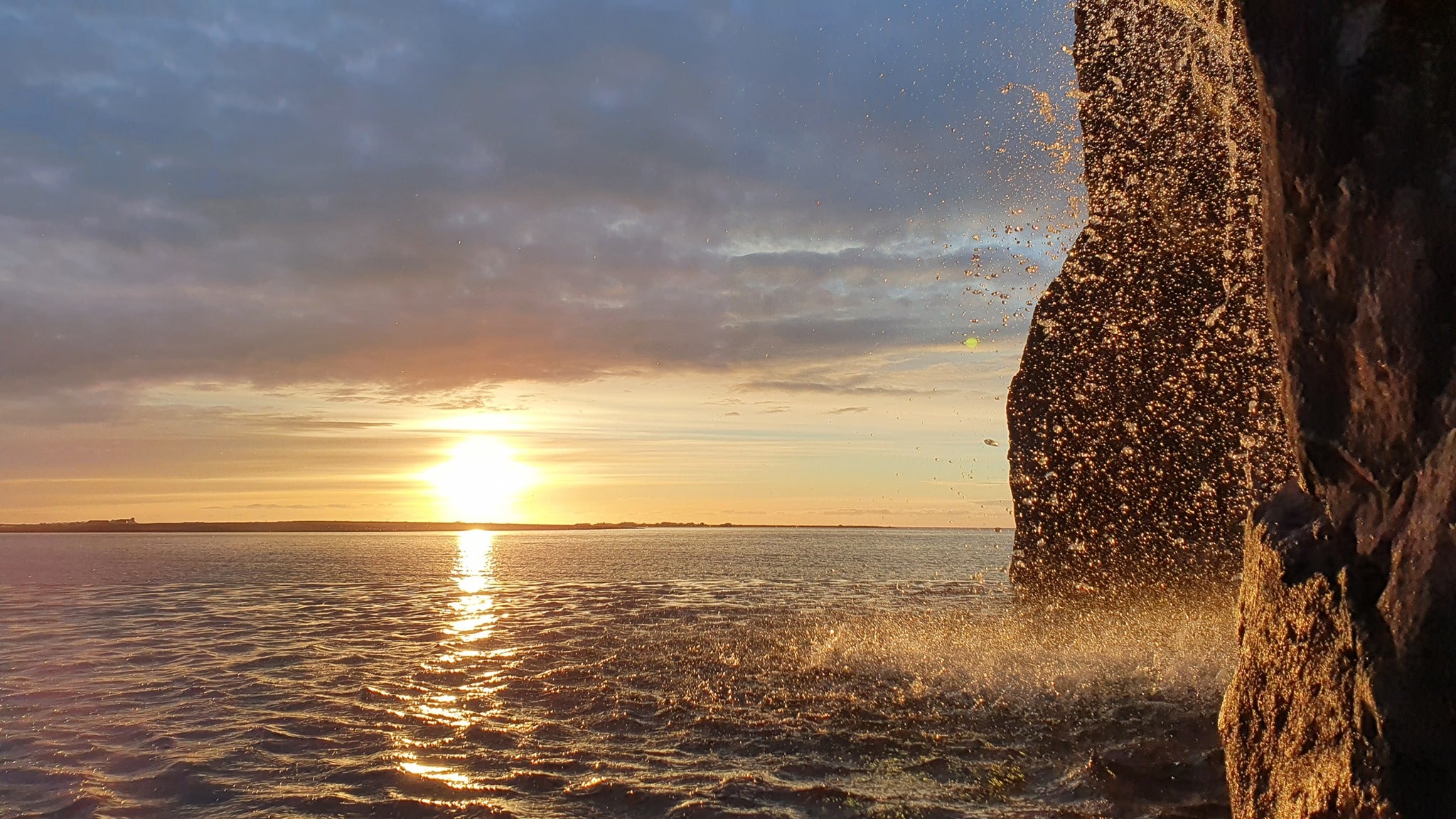 The sun sets over the water on the Reykjanes Peninsula, producing beautiful colors in the sky.