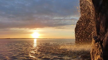 The sun sets over the water on the Reykjanes Peninsula, producing beautiful colors in the sky.